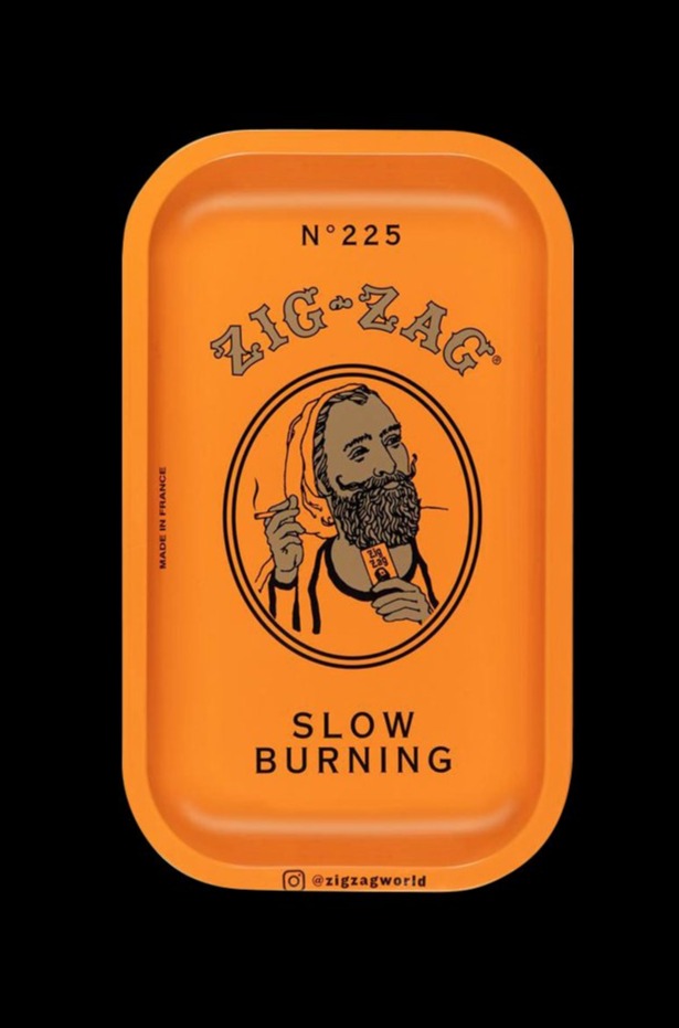 A close-up of the orange Zig Zag Small Metal Rolling Tray, displaying its minimalist design and branded text.