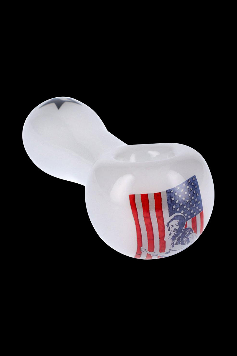 Angled close-up of the Rock Legends "Jimi USA" Spoon Pipe showing its white glass body and an American flag with Jimi Hendrix portrait on a black background.