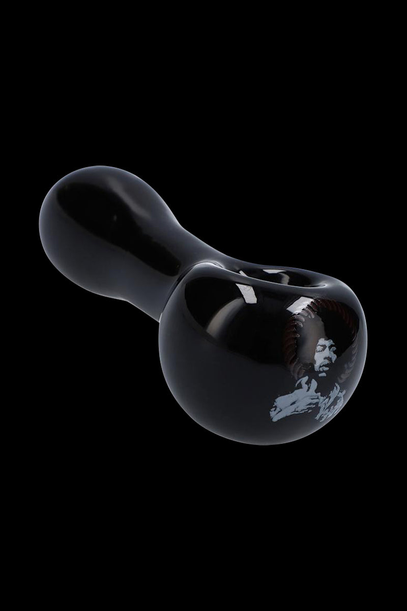Angled close-up of the glossy black Rock Legends Glass Spoon Pipe - Jimi NYC showing its rounded bowl and a white portrait decal on the side.