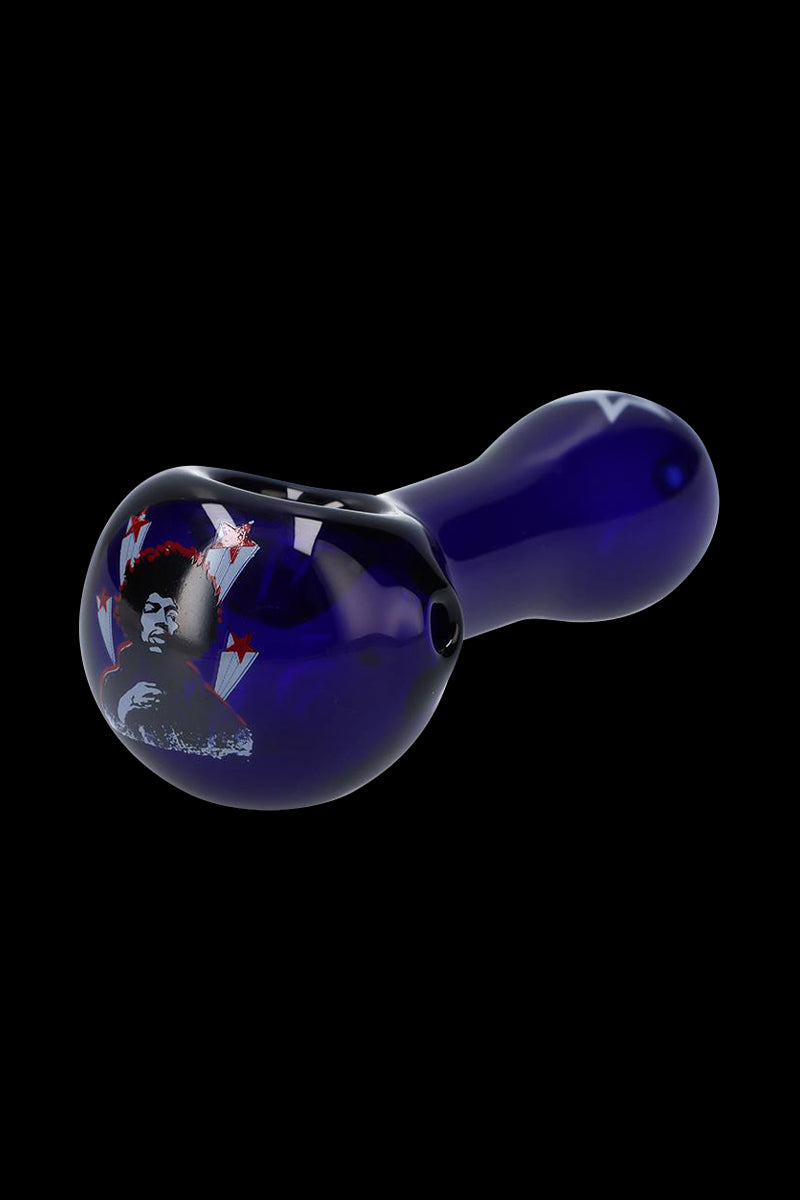 Angled close-up of the cobalt blue Rock Legends "Jimi Star" Glass Spoon Pipe showing its rounded bowl with a Jimi Hendrix graphic and star accents on a black background.