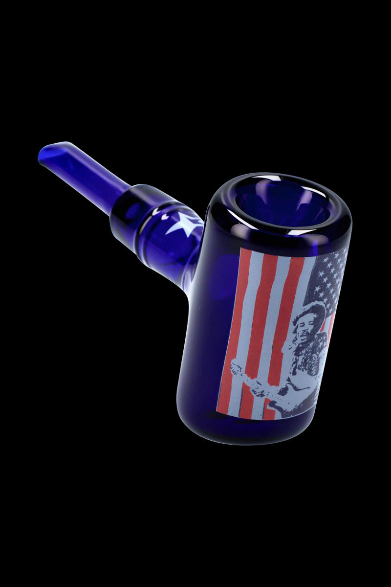 Angled close-up of the Rock Legends Sherlock Hammer Pipe - Jimi USA in deep blue glass with a guitar-playing Jimi Hendrix portrait over red-and-white stripes.