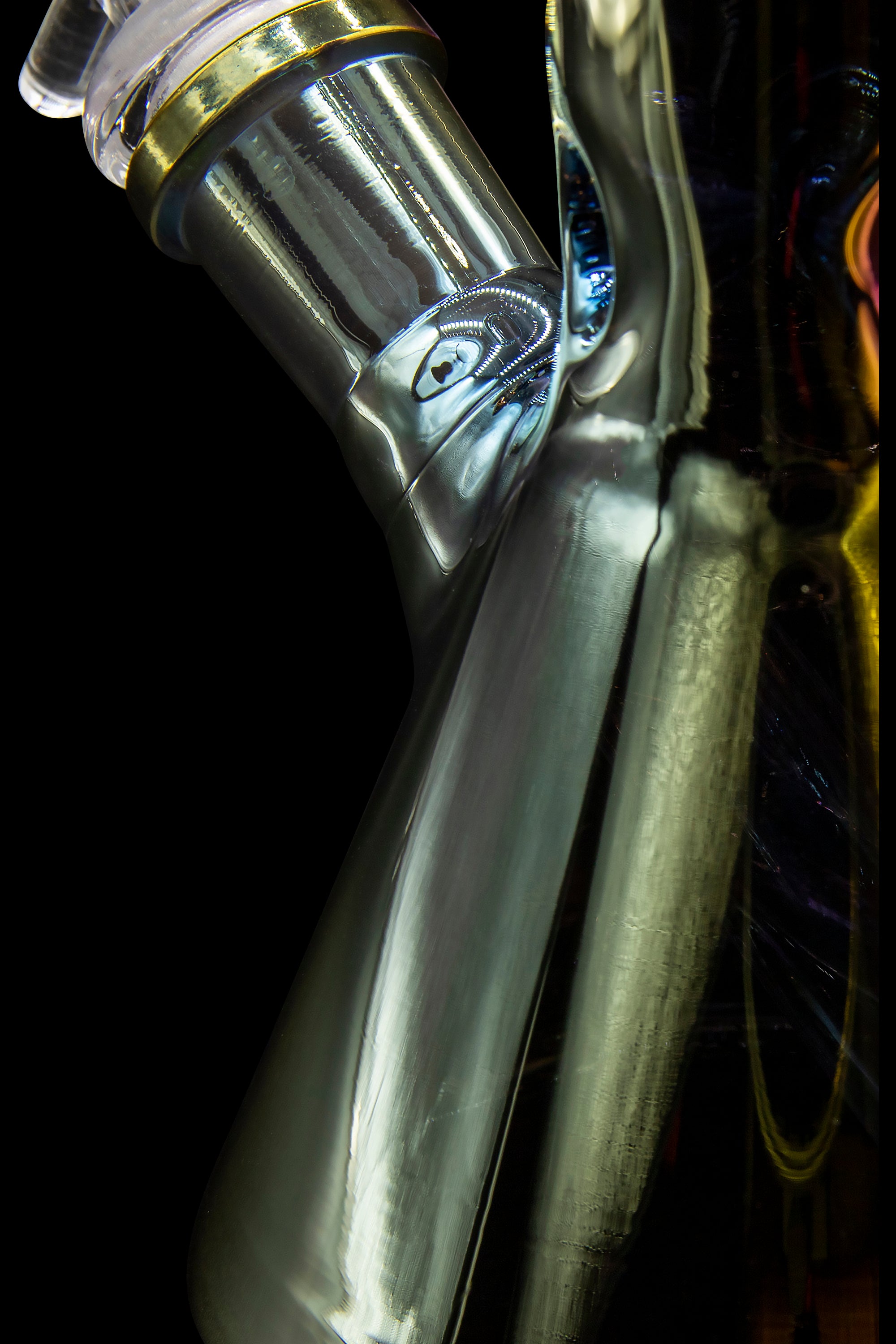 Close-up of a clear glass cannabis water pipe against a black background.