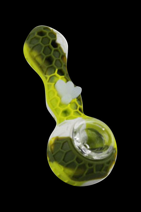 Angled top-down view of a bright yellow-green Silicone Bee Durable Hand Pipe with honeycomb pattern and a white heart accent against a black background.