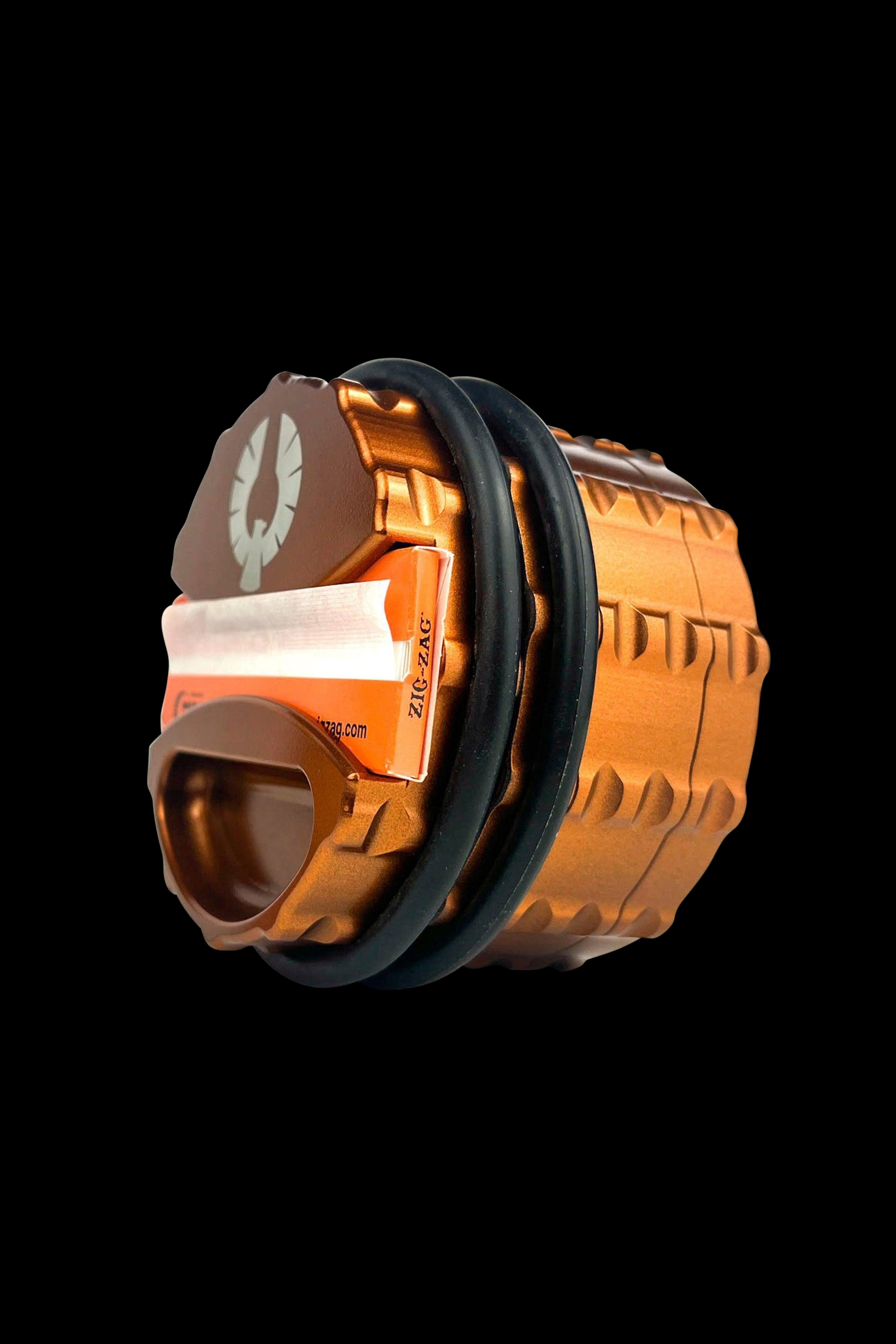 Ornate, copper-colored grinder with a partially visible Zig-Zag rolling paper insert.