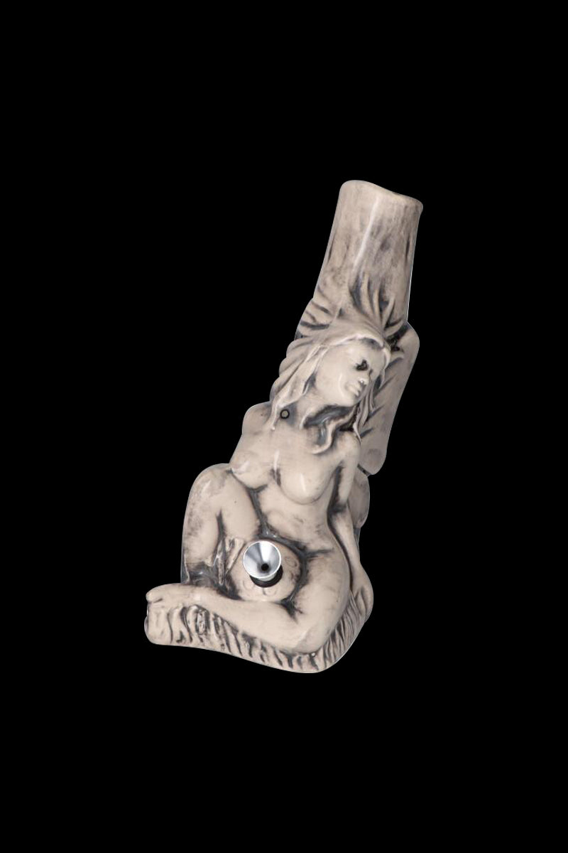 Angled front view of the Sleeping Maiden with Water Jug Ceramic Pipe showing a reclining nude maiden sculpted in pale ceramic against a black background