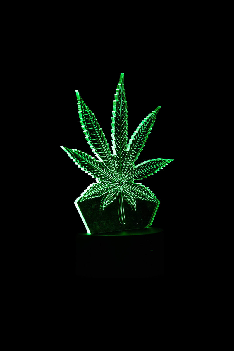 A vibrant 3D Cannabis Leaf Lamp casts a glowing green silhouette against a dark background, resembling a stylized plant form.
