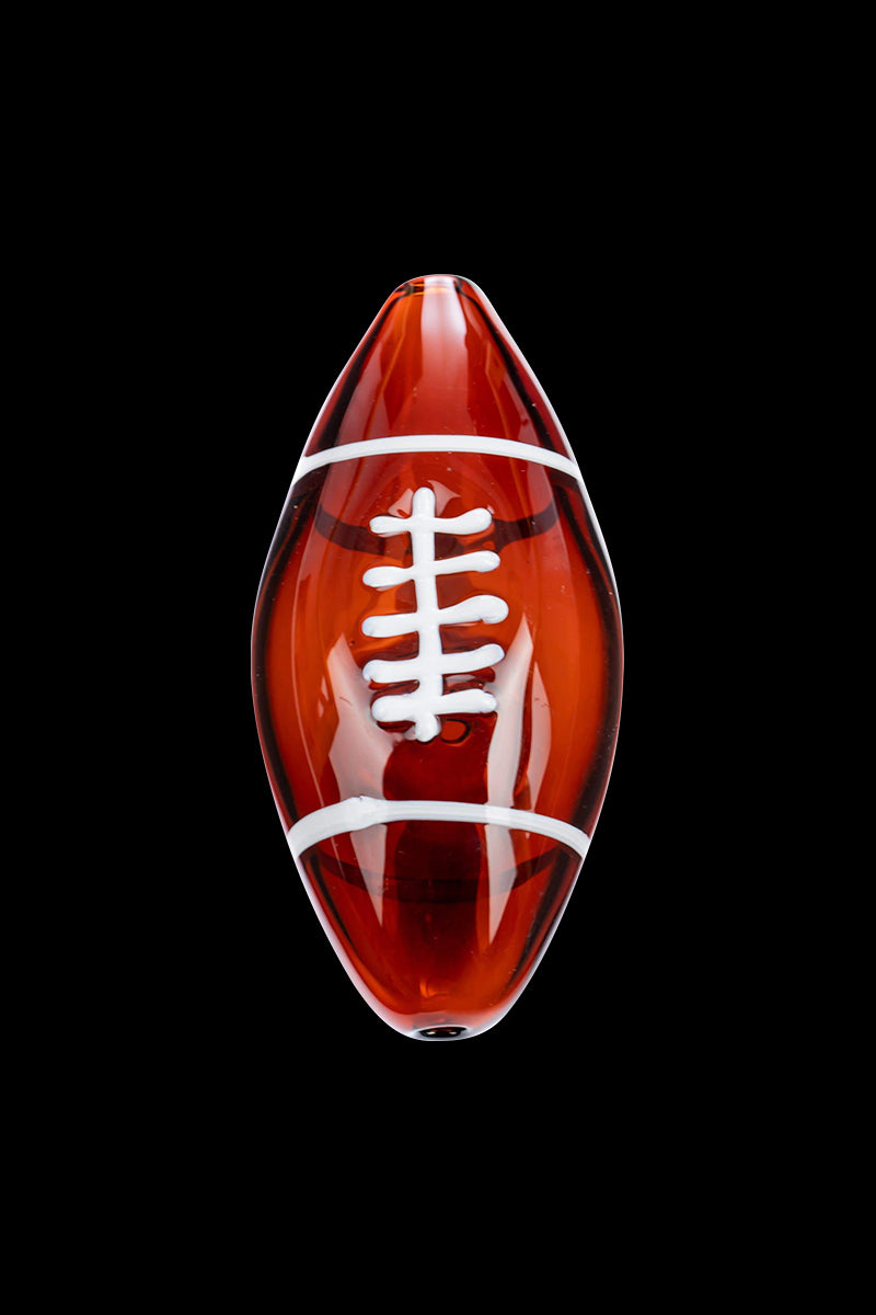Centered top-down view of the Football Hand Pipe, a glossy amber glass football with white laces against a black backdrop