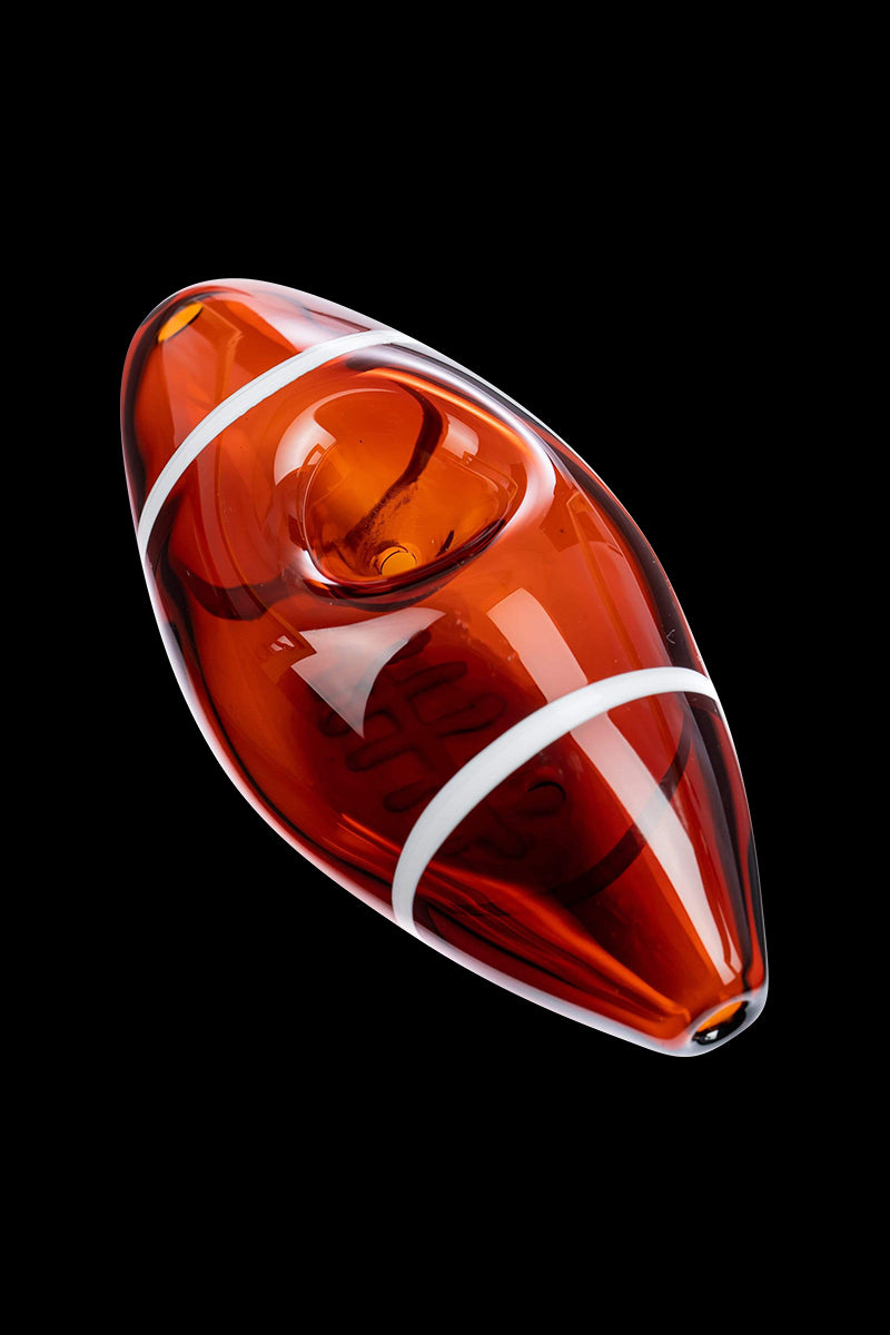 Angled close-up of a glossy amber Football Hand Pipe with white stripe accents against a solid black background