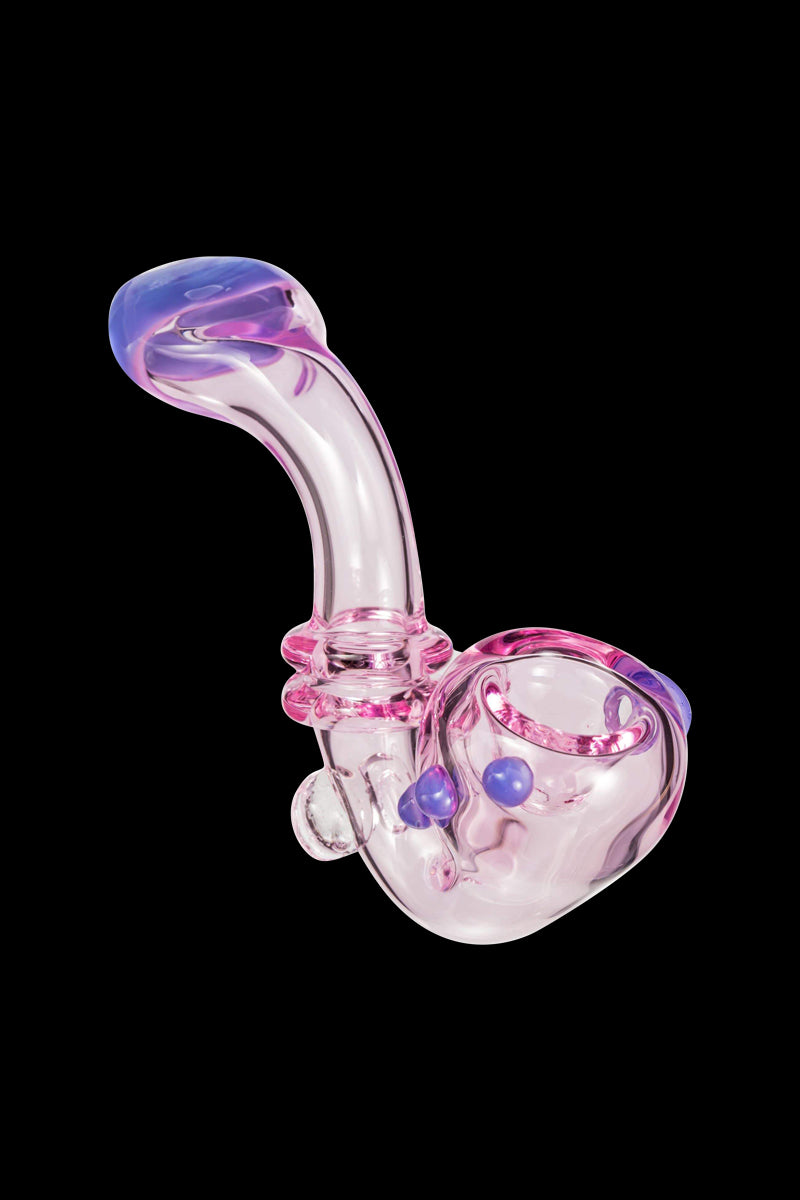 Angled close-up of the Maria Ring Sherlock Pipe showing a translucent pink glass body with a curved stem, blue accents, and a black background