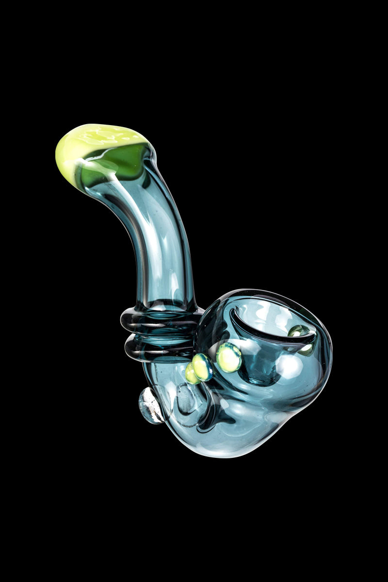 Angled close-up of the Maria Ring Sherlock Pipe showing a translucent teal glass body with lime green accents against black.