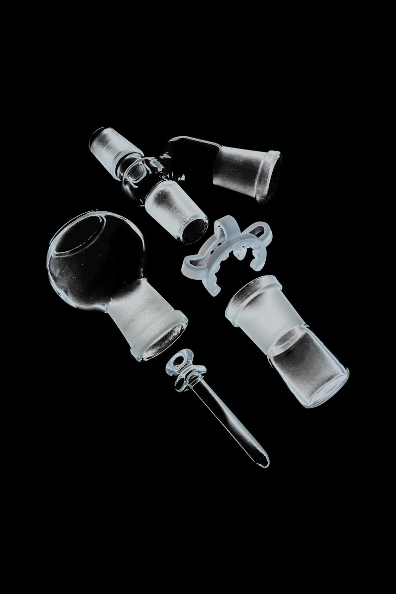 Top-down view of a disassembled Reclaim Catcher showing glass joints, a round glass chamber and a small plastic clamp against a black background