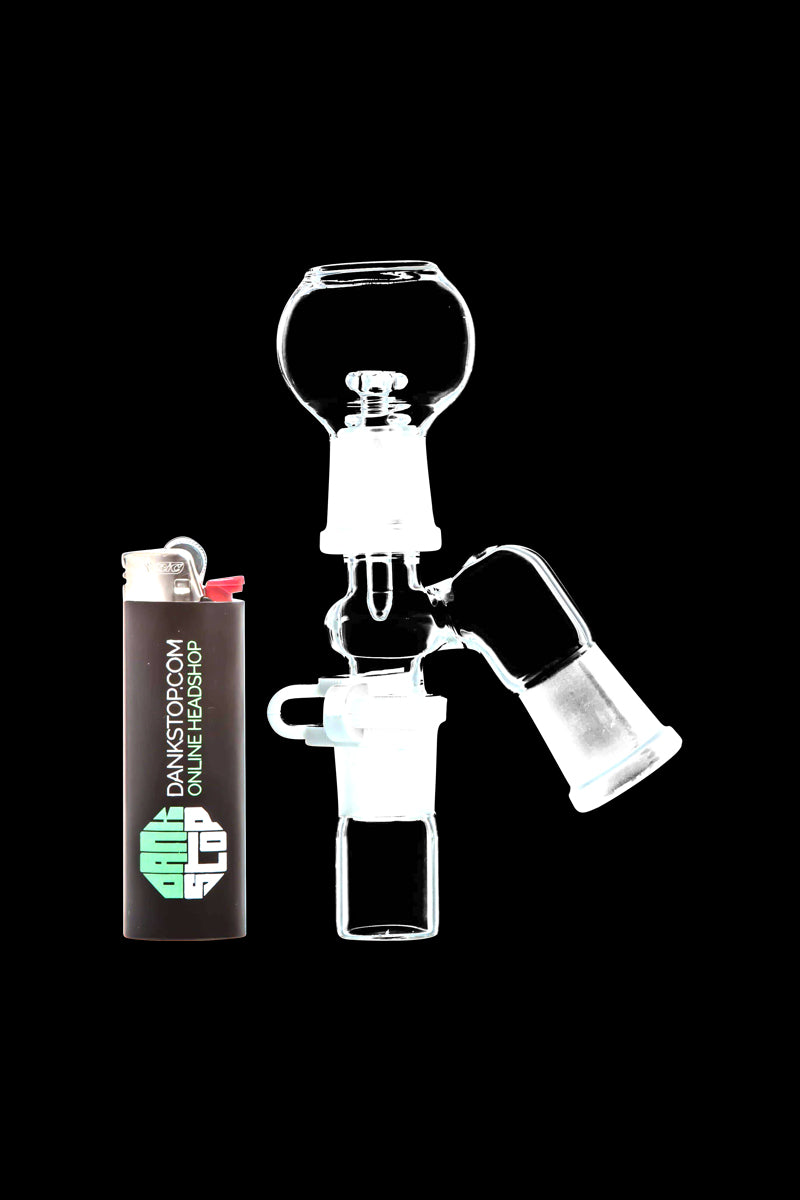 Center-framed close-up of the clear glass Reclaim Catcher showing a 45° male joint and bowl against a solid black background with a lighter beside it.