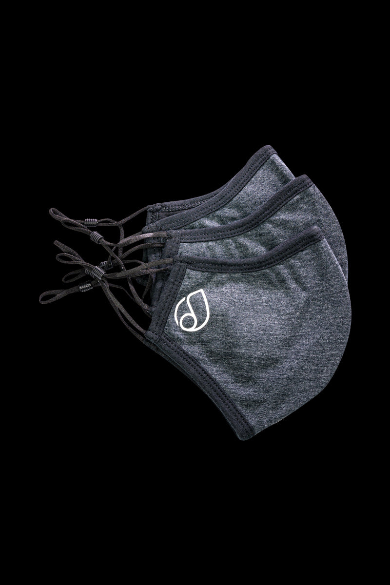 A close-up, angled view of the Reversible Cloth Mask, showing its folded fabric texture against a dark background.