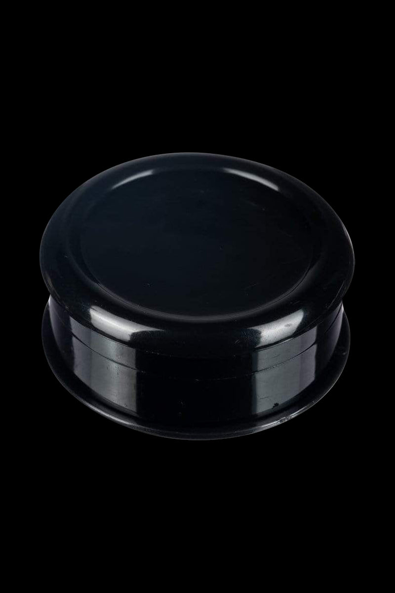 Close-up, top-down view of the Travel Herb Grinder & Stash Jar, showcasing its smooth, dark finish and circular design.