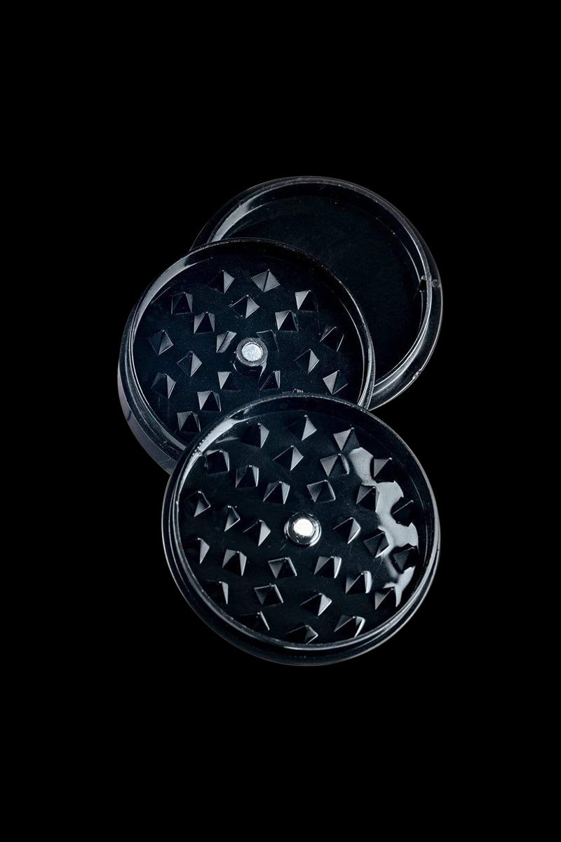 Overhead view of the Travel Herb Grinder & Stash Jar, showcasing its circular design and metallic finish against a dark background.