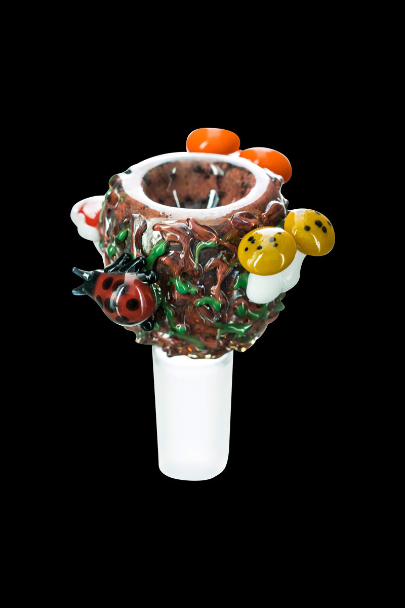 Close-up front view of the Empire Glassworks "Bug's Life" Bowl showing a textured brown nest with a red ladybug and yellow mushrooms.