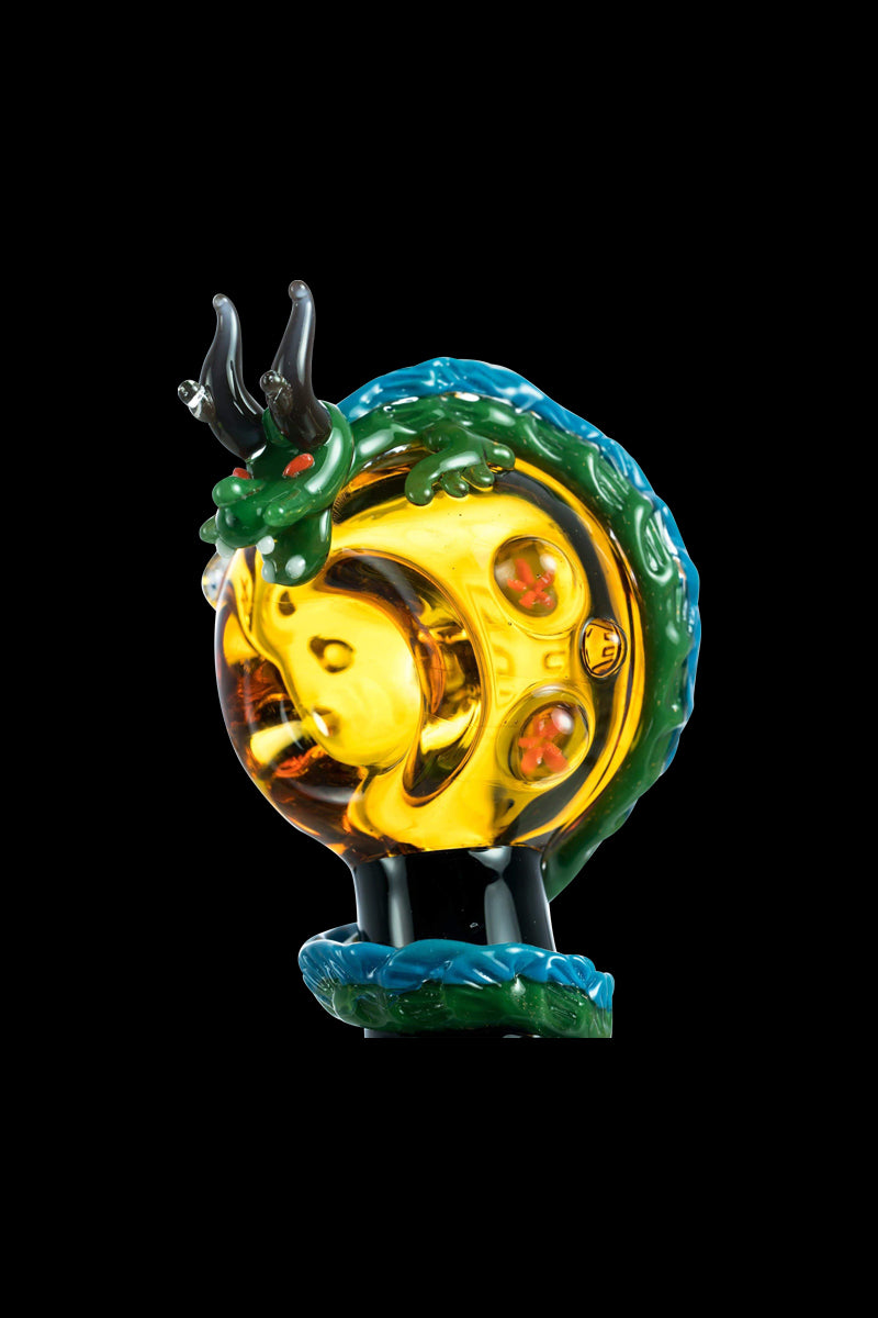 A detailed side view of the Empire Glassworks Dragon Sphere Small Spoon Pipe, showcasing colorful glasswork forming a dragon around a bowl.