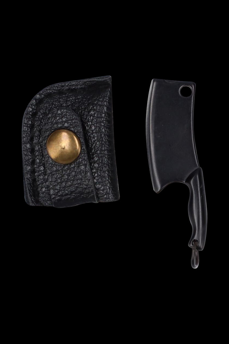 Top-down view of the THGC EX II Mini Chopping Knife with Cover showing the small black cleaver blade and its textured black leather cover with brass snap against a dark background