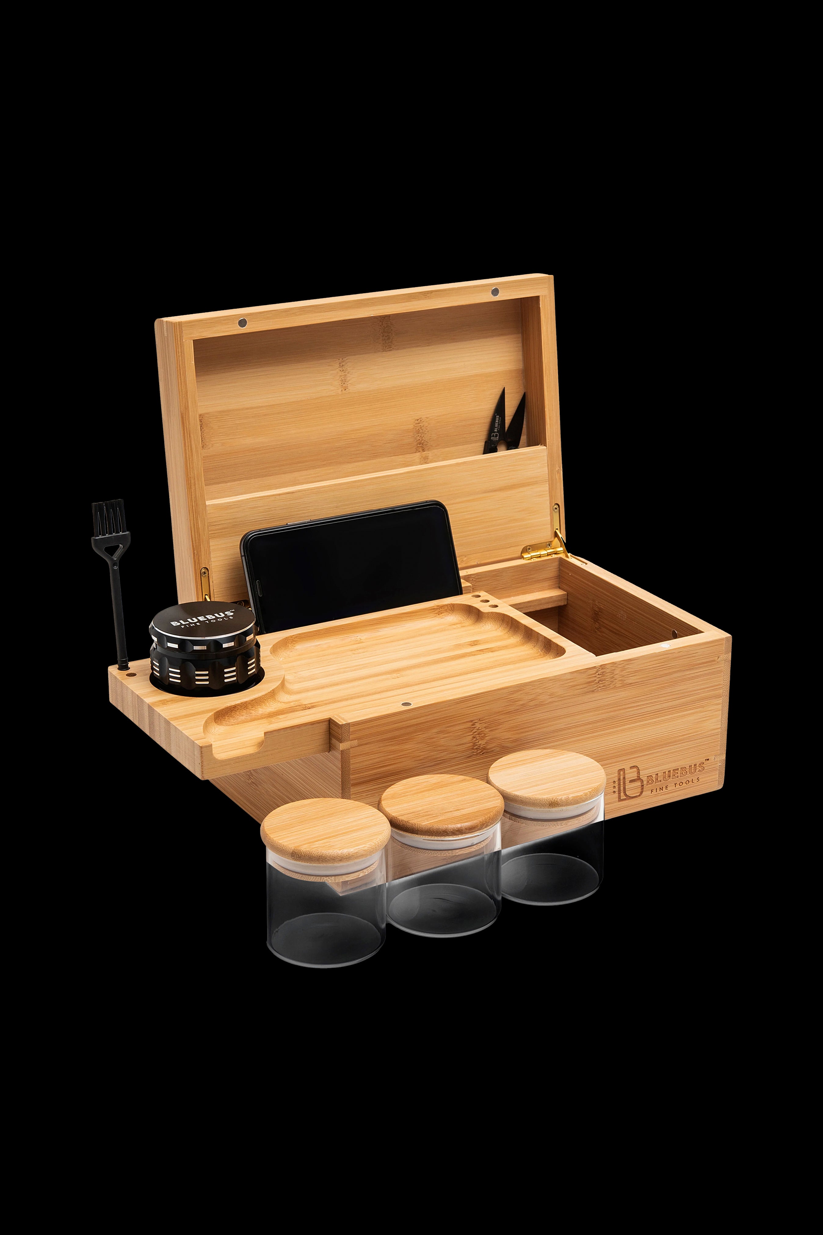 Wooden cannabis accessory box with grinder, jars, phone stand, and tools.