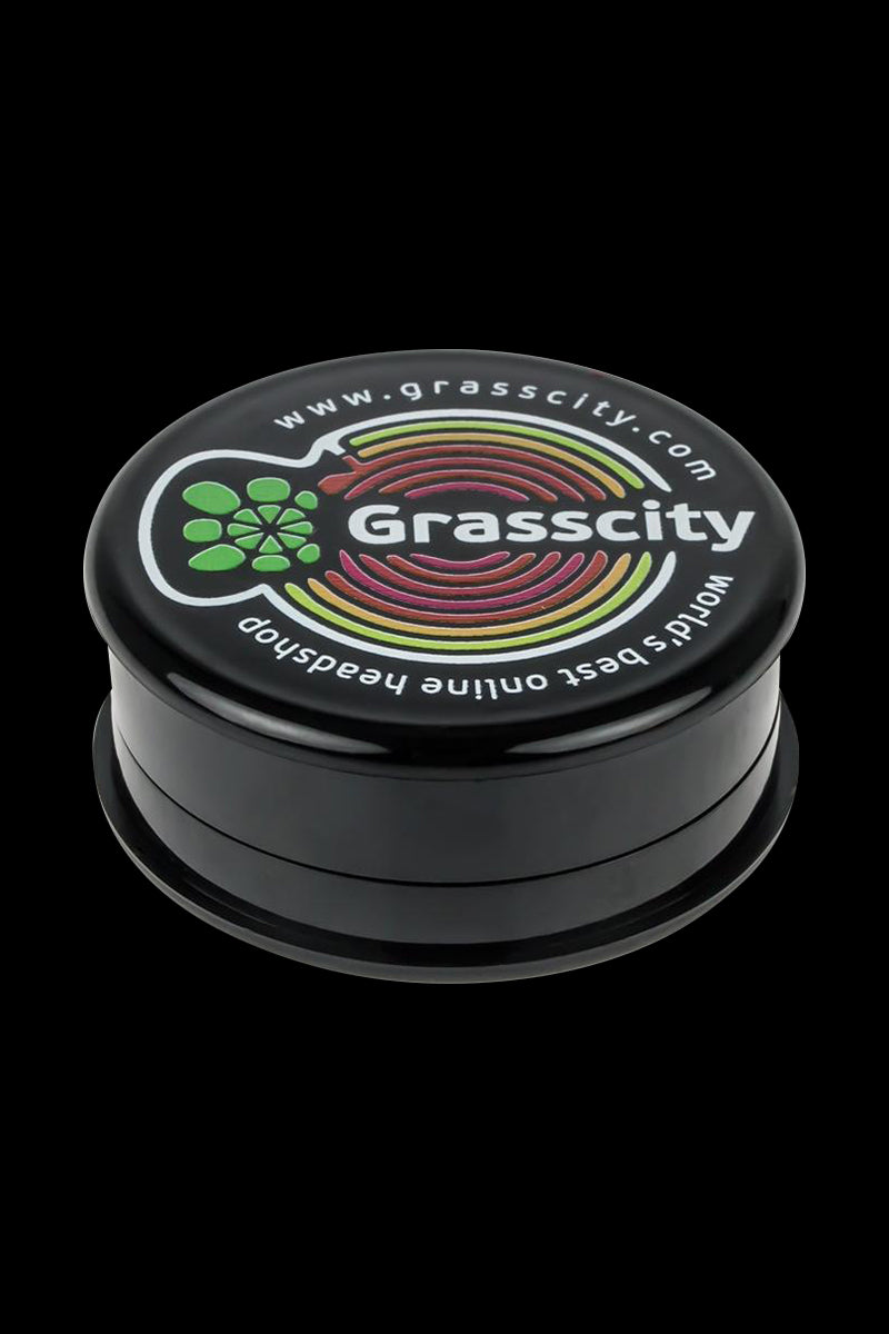 A close-up of the Grasscity Acrylic 3-Part Herb Grinder, showcasing its multi-tiered design against a dark backdrop.