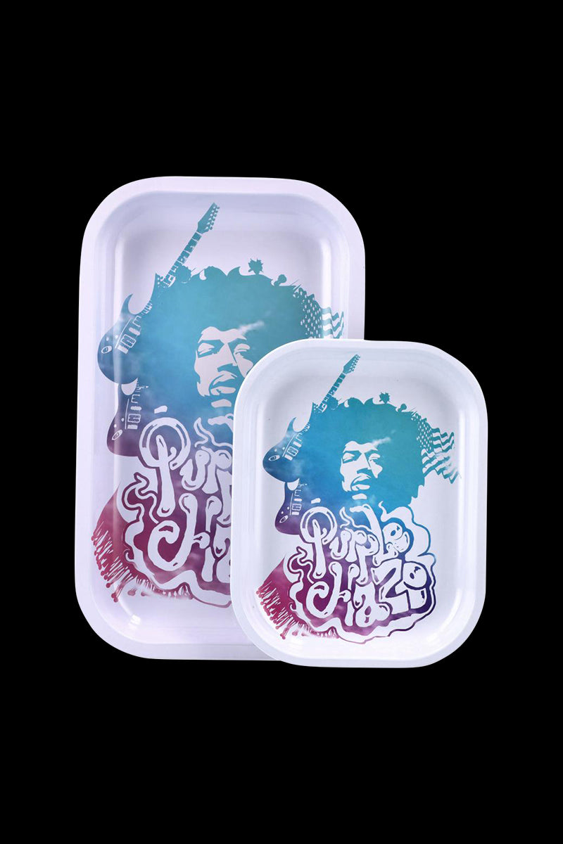 Two overlapping white trays photographed from above against a black background showing a blue-purple stylized face and guitar graphic on the Famous Brandz Jimi Purple Haze Rolling Tray