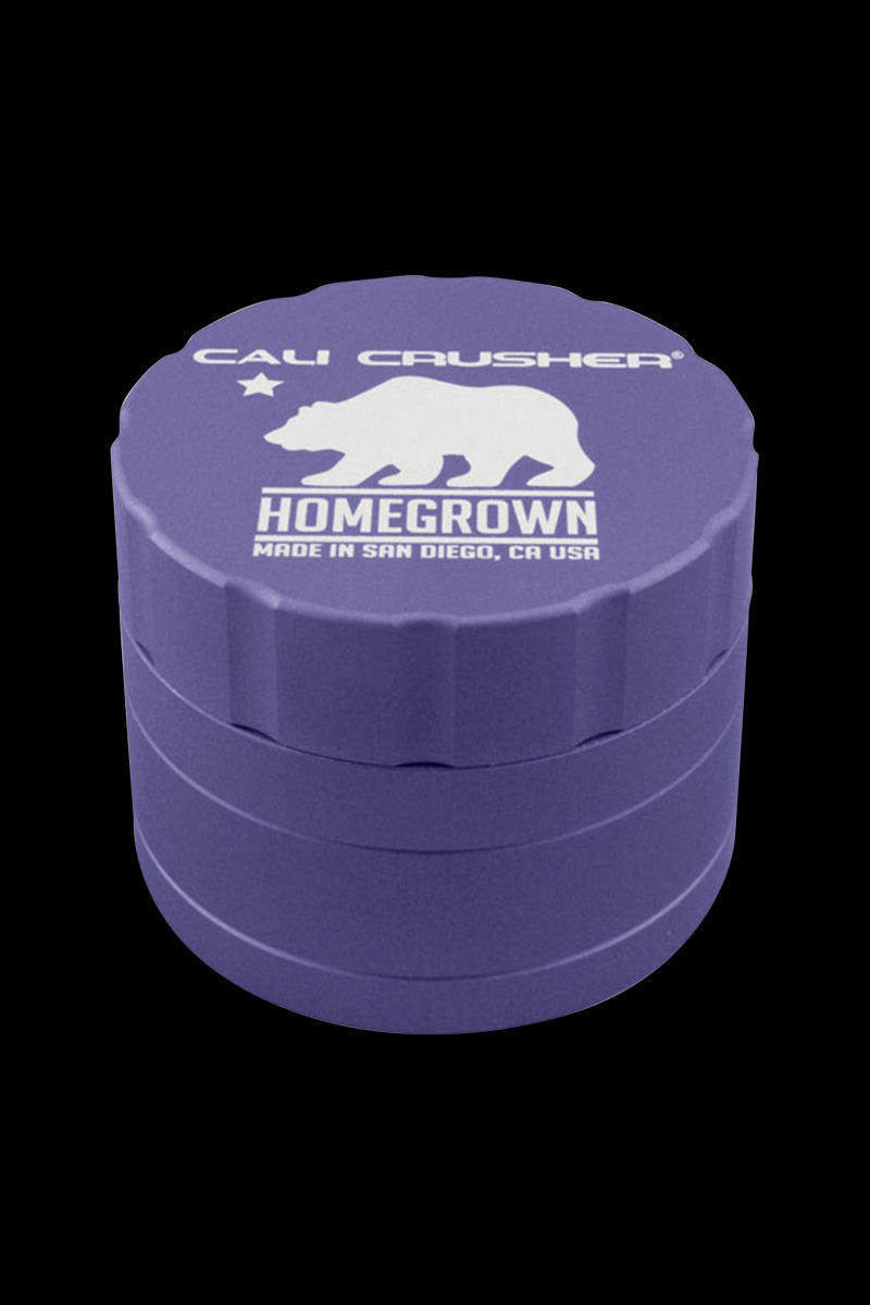 Top-down view of a purple Cali Crusher Homegrown 4-Part Grinder with white bear logo and text centered on a black background.