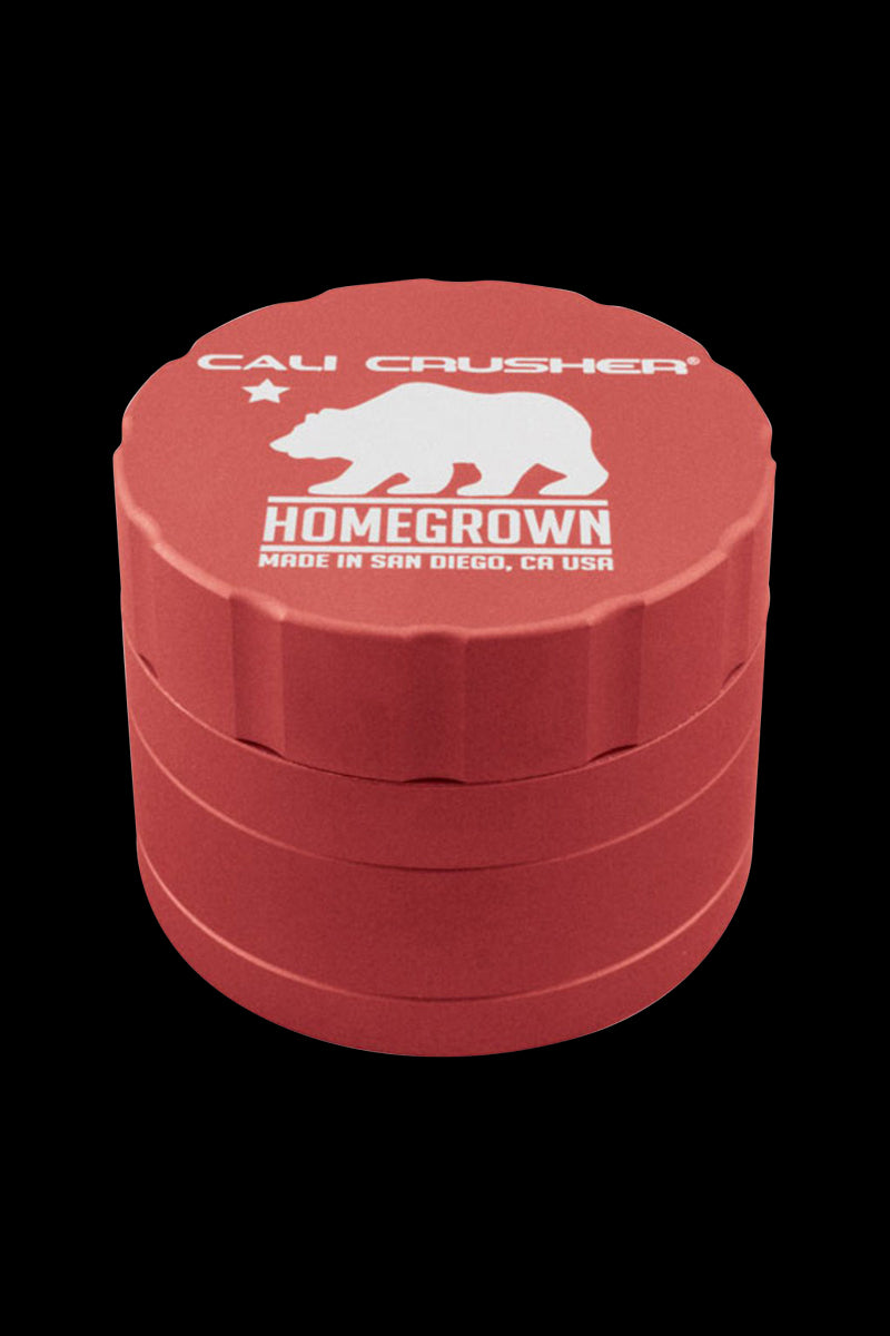Top-front view of a red Cali Crusher Homegrown 4-Part Grinder with white bear logo and text against a black background.