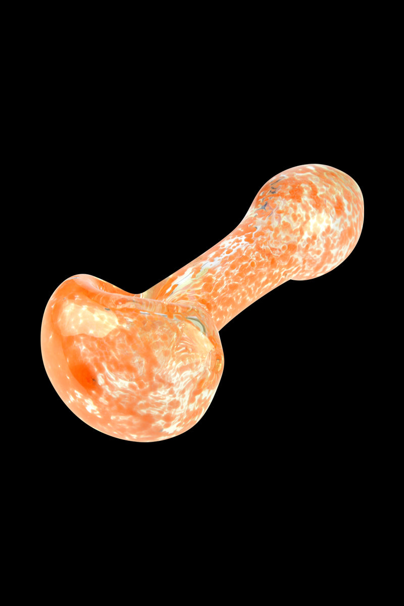 Angled close-up of the Glassheads Spoon Pipe with Scatter Frit showing orange-and-white mottled glass against a black background.