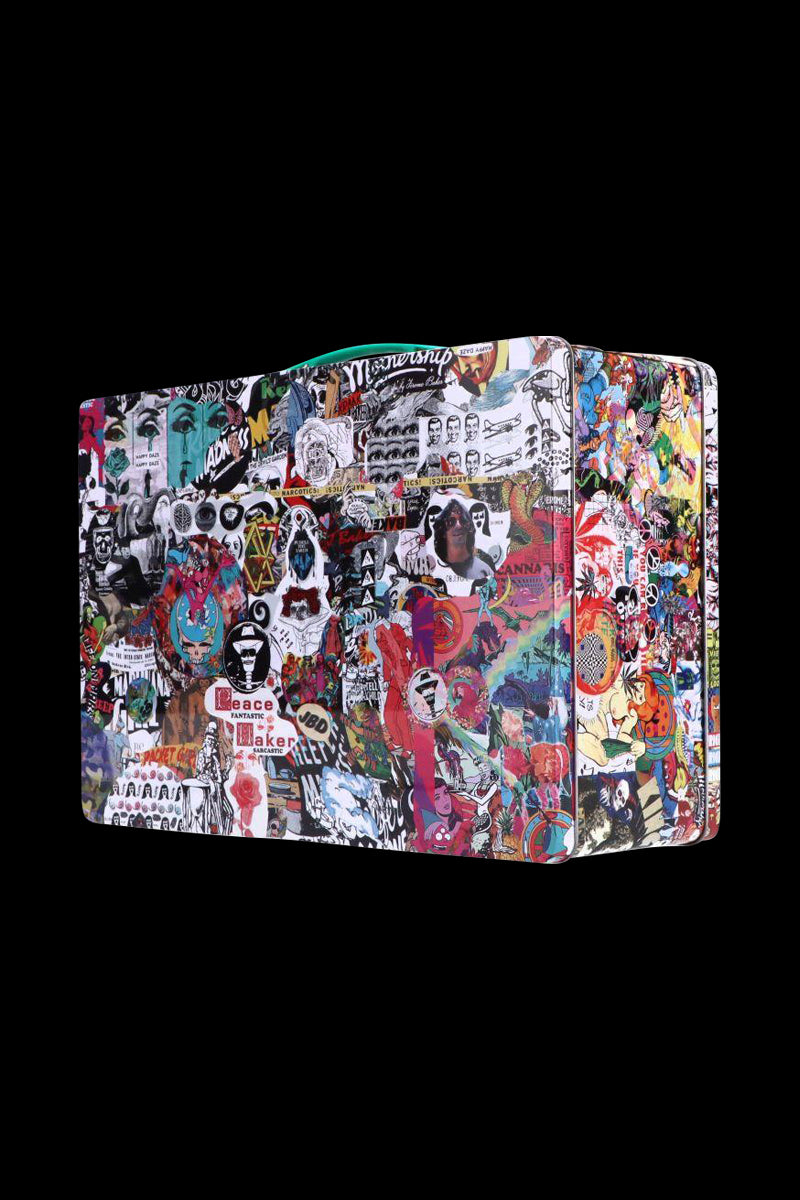 Angled view of a sticker-covered Jerome Baker Lunch Box against a solid black background, showing colorful collage panels and rounded edges.