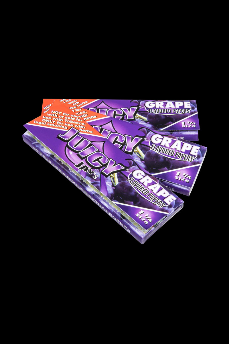 A close-up, angled shot of Classic 1-1/4" Size Flavored Rolling Papers featuring bold grape-themed graphics on a vibrant purple packet.