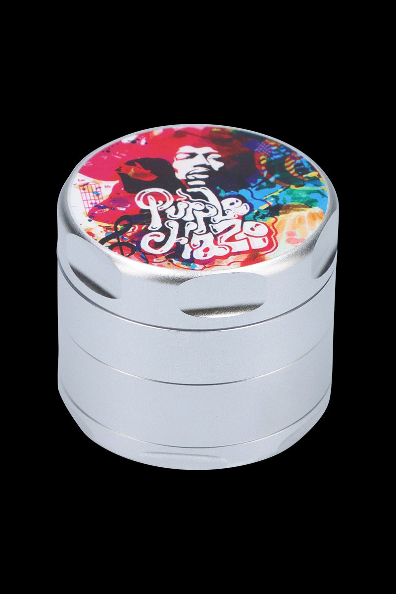 Close-up, three-quarter view of the Rock Legends "Jimi Rainbow Haze" Grinder showing its silver stacked body and a colorful psychedelic portrait on the lid.