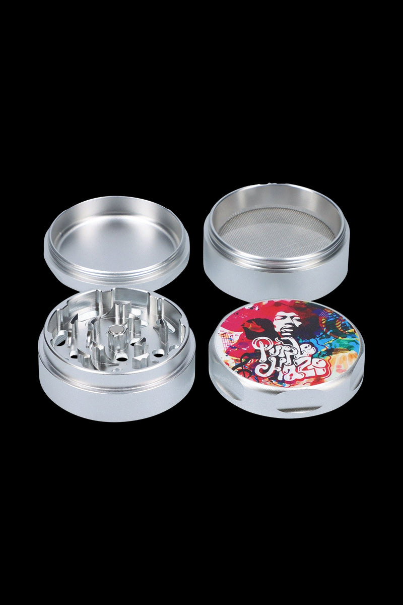 Top-down view of the Rock Legends "Jimi Rainbow Haze" Grinder showing its four silver parts laid out with the colorful Jimi Hendrix artwork on the lid.