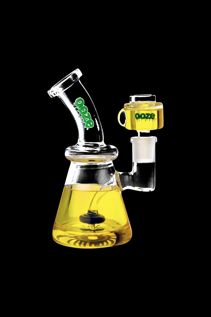 Angled front view of the Ooze Glyco Glycerin Chilled Bong with yellow glycerin liquid in its beaker base and matching yellow accents against a black background