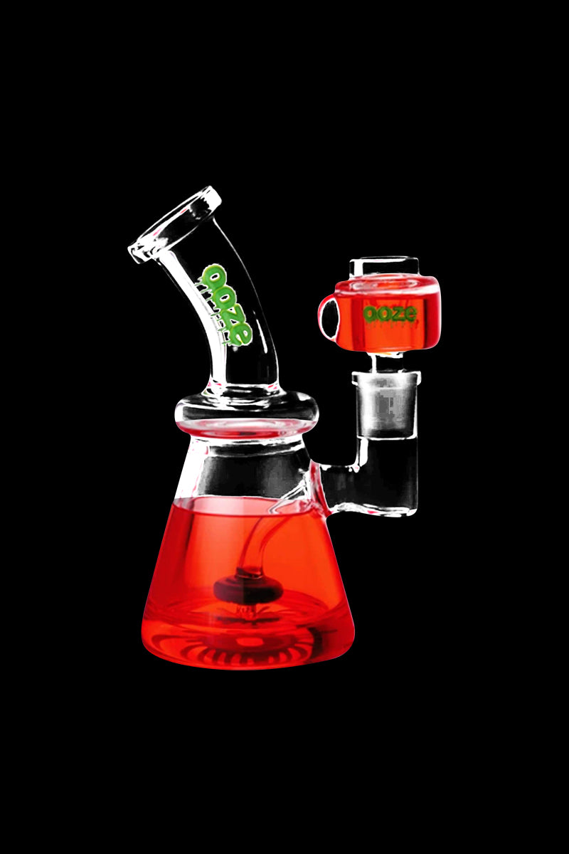 Front three-quarter view of a scarlet Ooze Glyco Glycerin Chilled Bong against a black background, highlighting its angled neck, beaker base and red chilled chamber.