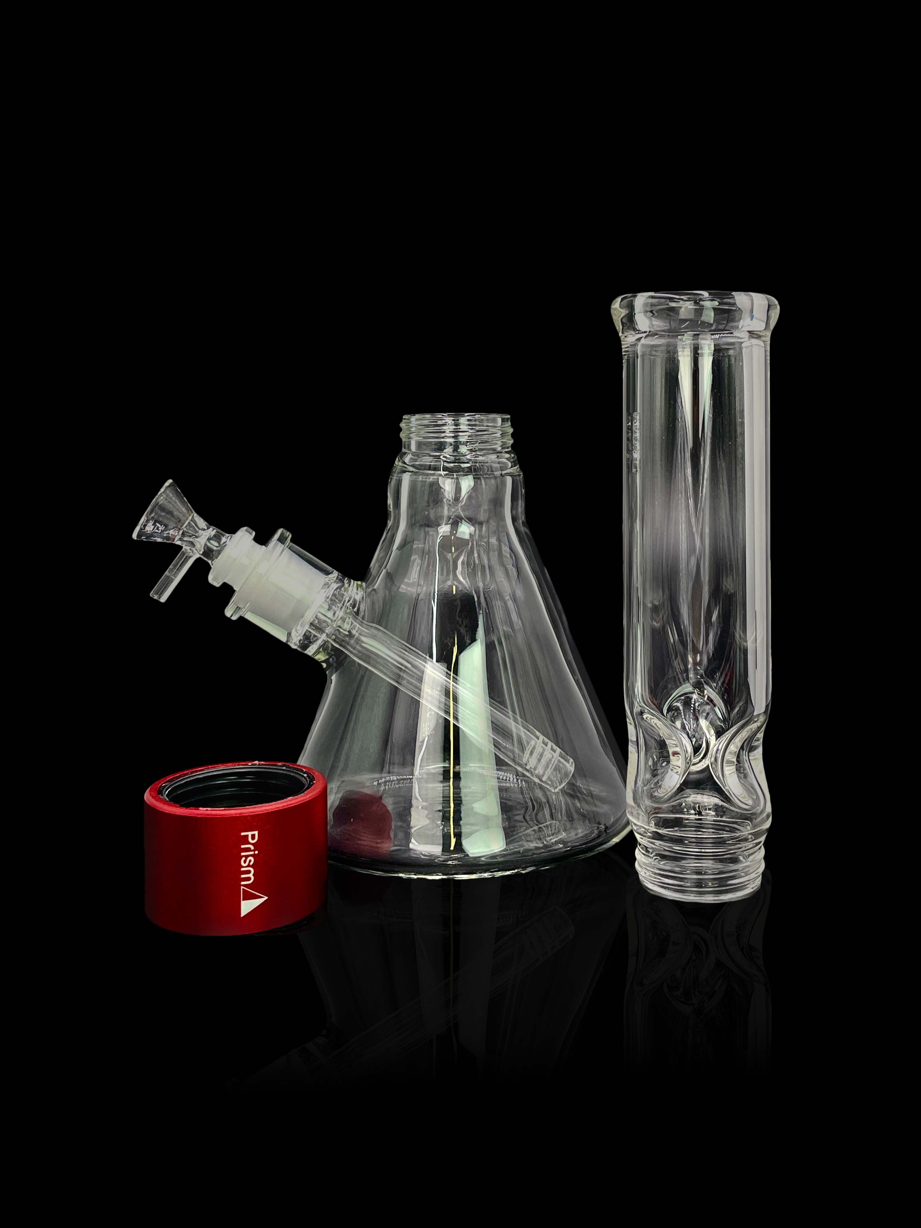 A front view of the Prism Water Pipes Starter Kit, showing the clear glass pipe beside its red packaging on a dark surface.