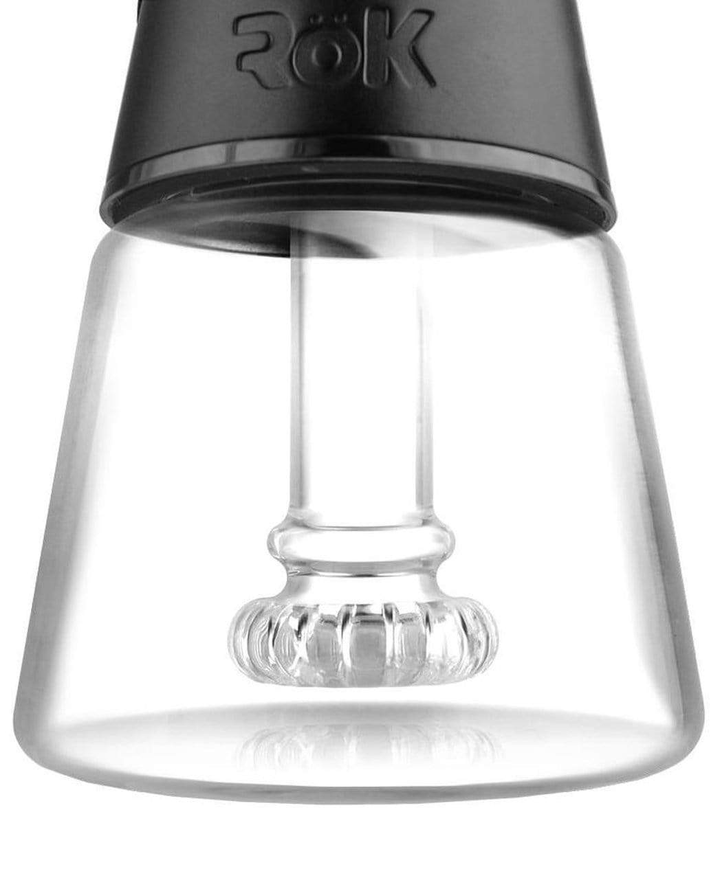 Close-up of a glass dab rig with a quartz banger inside, branded “ROK.”