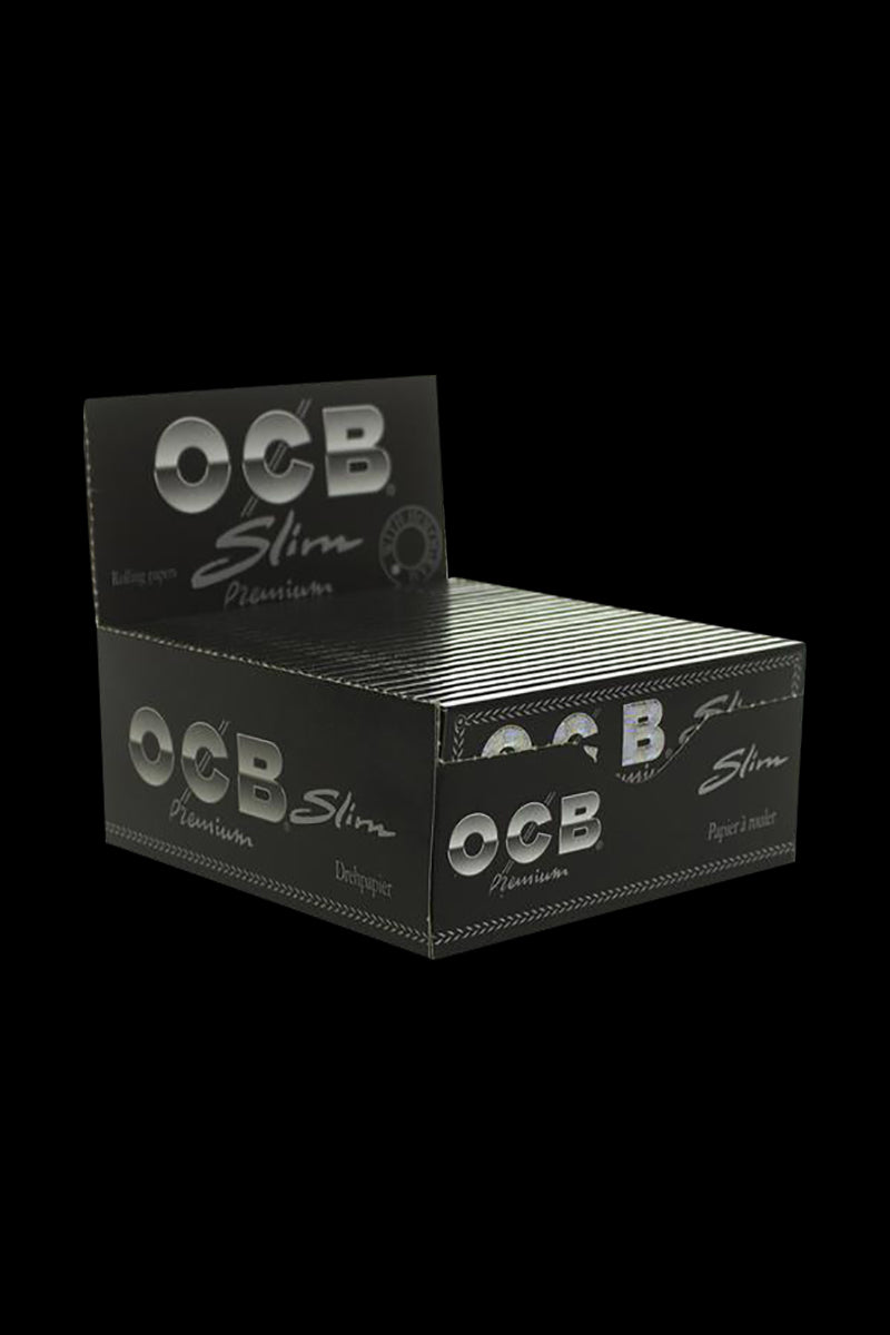 A stack of OCB Premium Single Wide Rolling Papers against a plain black background, viewed from a slightly angled, close-up perspective.