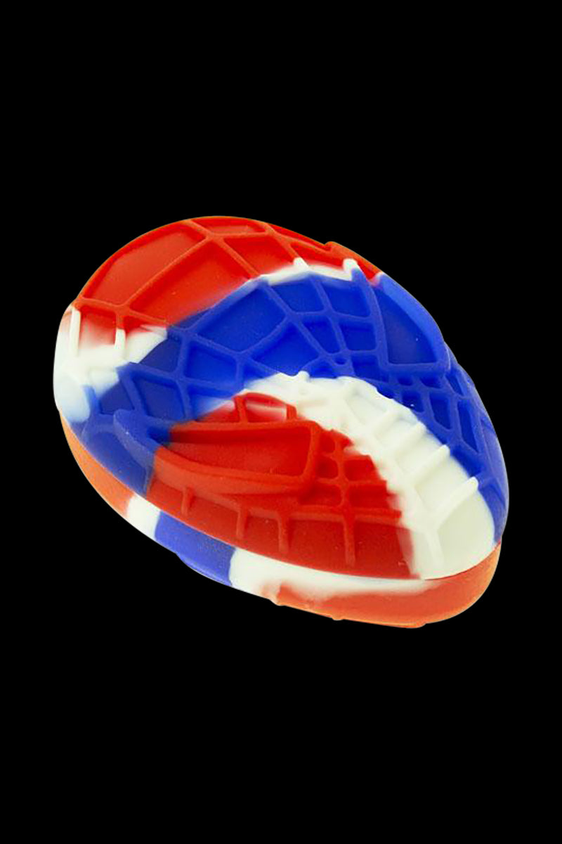 Angled close-up of a red, white, and blue Silicone Non-Stick Teardrop Stash Container showing textured grid details against a black background