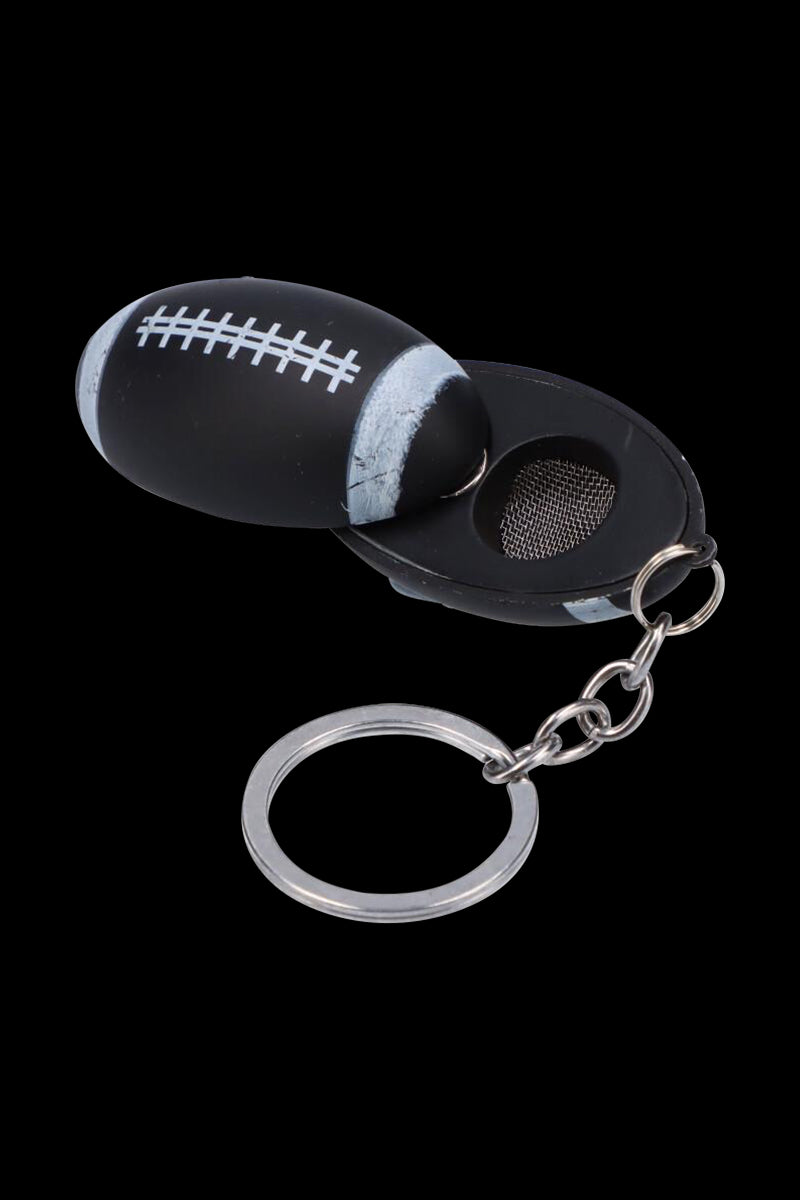 Close-up of the American Football Metal Hand Pipe with Key Chain showing a black football-shaped pipe opened to reveal a mesh bowl.