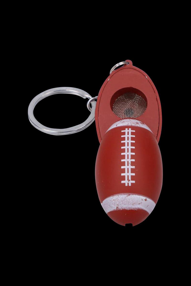 Top-down view of the American Football Metal Hand Pipe with Key Chain showing a red football-shaped pipe with white laces and its attached silver key ring against a black background