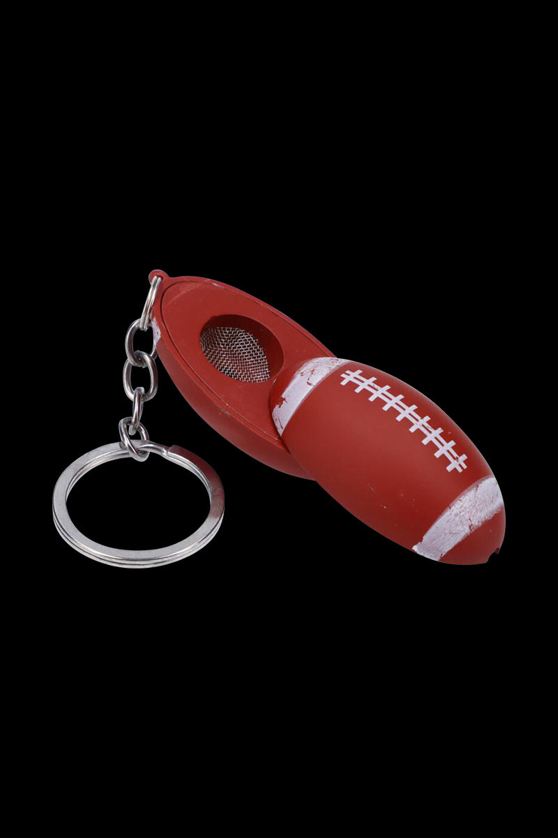 Close-up angled view of the American Football Metal Hand Pipe with Key Chain showing the red football-shaped pipe, mesh bowl, and silver key ring.