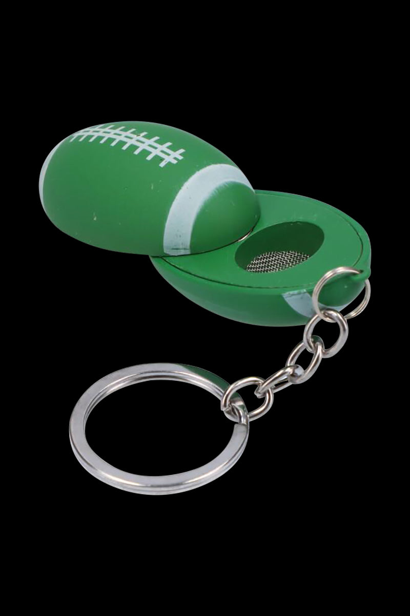 Close-up of the American Football Metal Hand Pipe with Key Chain showing a green football-shaped shell opened to reveal a mesh bowl and silver key ring.