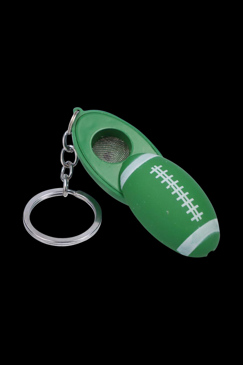 Close-up on a green American Football Metal Hand Pipe with Key Chain shaped like a football, shown open to reveal its metal bowl.