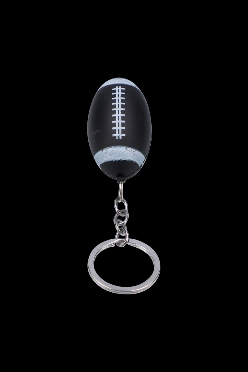 Top-down view of the American Football Metal Hand Pipe with Key Chain shaped like a small black football with white laces.