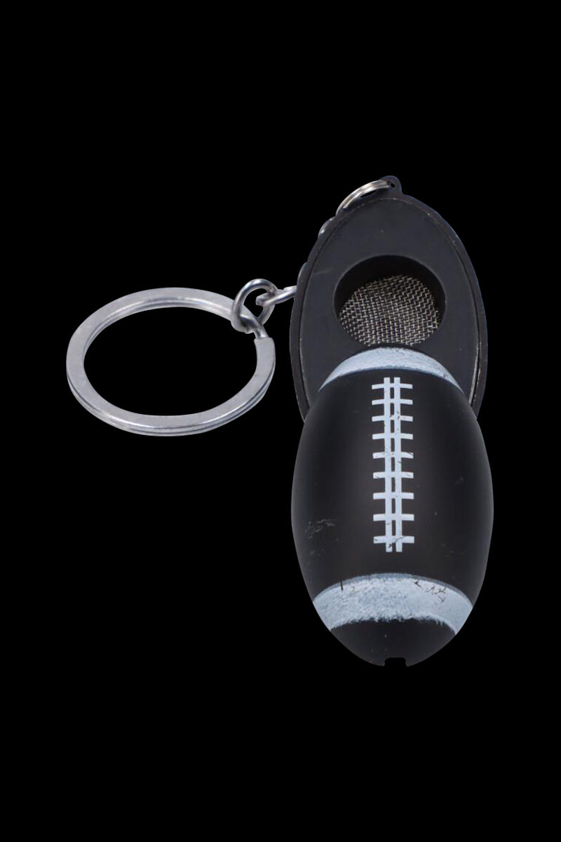 Close-up, top-down view of the American Football Metal Hand Pipe with Key Chain showing the black football-shaped bowl, white laces, attached metal key ring, and mesh screen.