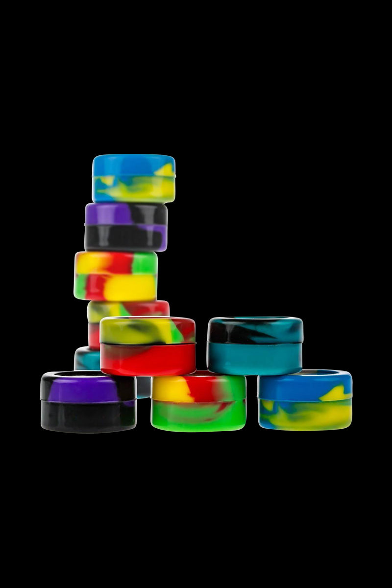 A top-down view of several Silicone Non-Stick Stash Containers in varying colors against a dark, solid background.