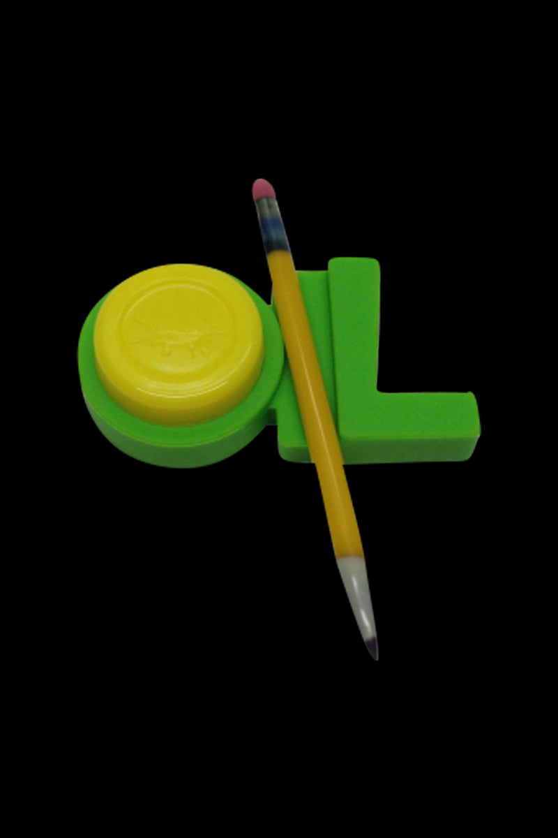 Angled top-down view of a red NoGoo - 420 Oil Station piece (shown here in green with a yellow lid) resting on a black background with a pencil across it