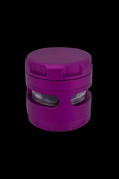 Purple cannabis grinder isolated on a black background.