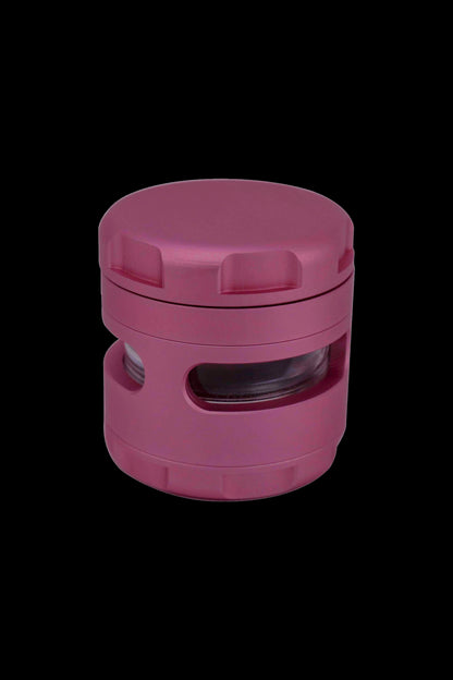 Pink four-piece cannabis grinder with a clear viewing window.
