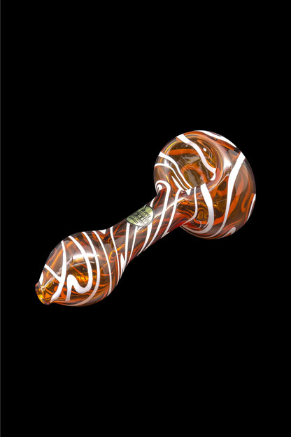Orange and white swirled glass pipe isolated on a black background.